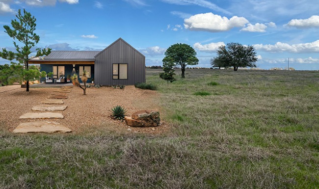 Innovative Design wide view of one of the Tree Tops homes showing nearby green turf